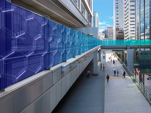 View of skyway walking bridge with people walking below on sidewalk.
